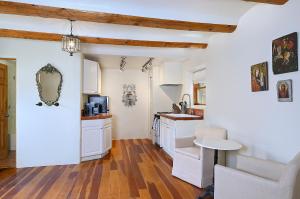 a kitchen with white cabinets and a table at Dos Hermanas Casita 6 Downtown Courtyard Patio in Santa Fe