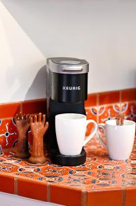 a coffee maker and two cups on a counter at Dos Hermanas Casita 6 Downtown Courtyard Patio in Santa Fe