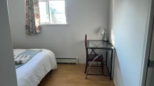 a bedroom with a bed and a desk and a window at Big band home in Burnaby