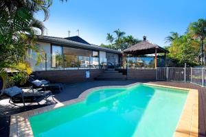 a swimming pool in front of a house at Sandy Shores - Canalfront Oasis, Guest Suite, Pool in Gold Coast