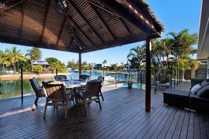 una terraza de madera con mesa, sillas y sofá en Sandy Shores - Large Family Retreat, en Gold Coast