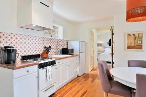 a kitchen with white cabinets and a table in a room at Dos Hermanas Casita 2 Downtown Courtyard in Santa Fe