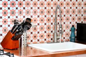 a kitchen counter with a kitchen sink with a faucet at Dos Hermanas Casita 2 Downtown Courtyard in Santa Fe +24 photos