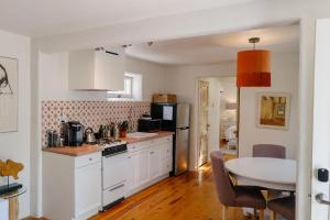 a kitchen with white cabinets and a table in it at Dos Hermanas Casita 2 Downtown Courtyard in Santa Fe