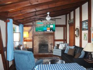 un soggiorno con camino e TV di Birch Shores Resort - The Aspen Cottage a Empire