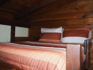 Posto letto in camera con pareti in legno. di Birch Shores Resort - The Aspen Cottage a Empire