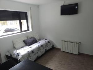 a room with a bed and a window and a television at alojamiento temporario in Tres Arroyos