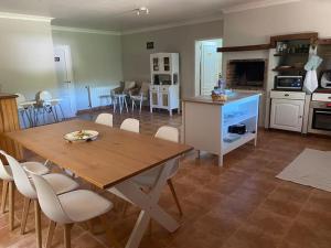 a kitchen and living room with a wooden table and chairs at Quinta O Cabecinho in Torres Novas
