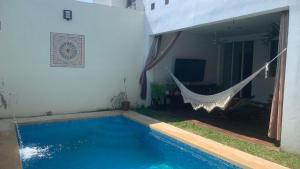 a swimming pool with a hammock next to a house at Casa Intensamente in Jesús María +1 photo