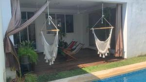 two hammocks hanging on a porch with a pool at Casa Intensamente in Jesús María