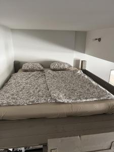 un letto con due cuscini sopra in una stanza di Blooming sky a Budapest