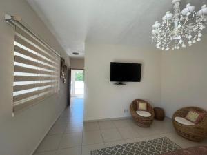 - un salon avec deux chaises et une télévision à écran plat dans l'établissement La Villa de Sophie, à Acapulco