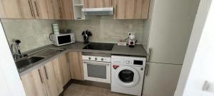 a kitchen with a sink and a washing machine at Casa Riquelme in Collado-Villalba