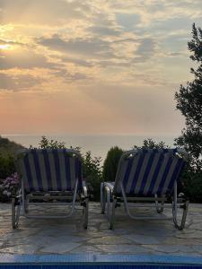 two blue and white chairs sitting next to the ocean at Villa Neimi in Ksamil