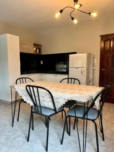 a kitchen with a table and chairs and a refrigerator at Hospedaje Los Lapachos in Libertador San Martín