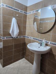 a bathroom with a sink and a mirror at Drilon Apartment in Sarandë
