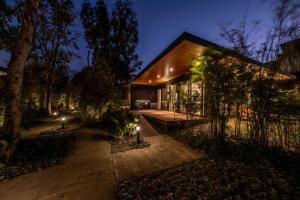 大雅台Ananda Cabin - Ezra Viniti Resort的夜晚在树林里带灯的房子