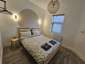 a bedroom with a bed and a table and a window at Urban Oasis 2 bed apartment in Manchester