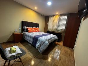 利马Matty House的一间卧室配有带橙色枕头和椅子的床