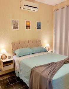 1 dormitorio con 1 cama con sábanas azules y 2 lámparas en Casa Barracuda, en Búzios