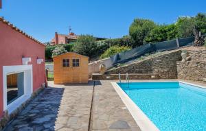 a swimming pool in a yard next to a building at Pet Friendly Home In Stintino in Stintino