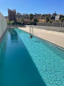 ビーニャデルマールにあるDepartamento en Concón, sector Costa de Montemarの水中のプールに入っている