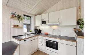 Una cocina con gabinetes blancos y un fregadero. en Dünenpark 2D - Dorf 4, en Travemünde