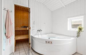 a white bathroom with a tub and a window at Three-Bedroom Holiday Home In Otterup in Otterup