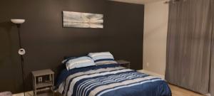 un dormitorio con una cama con sábanas azules y blancas en A Stay with the Owusu's, en Dieppe