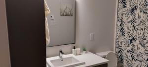 Un baño blanco con lavabo y espejo. en A Stay with the Owusu's, en Dieppe