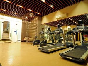 a gym with several treadmills and machines in a room at Cozy Corner Haven near Venice Grand Canal Mall in Manila