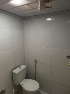 a white bathroom with a toilet and a ceiling at Suíte com entrada independente in Ubajara +3 photos