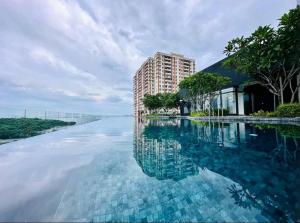 a large pool of water next to a building at 1408 Georgetown New Condo City View infinity pool in Jelutong