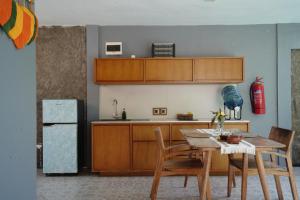 a kitchen with a table and chairs and a refrigerator at A Villa Gili Air in Gili Air