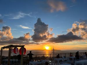 a sunset on the beach with people watching the sun set at Yukurina Resort Okinawa in Motobu