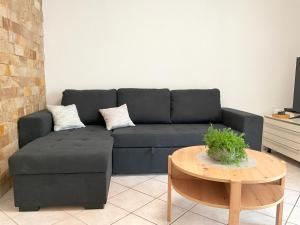 a black couch in a living room with a table at Emica's holiday home in Koper