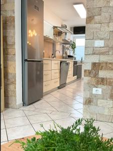a large kitchen with a stainless steel refrigerator at Emica's holiday home in Koper