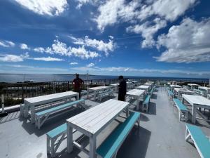a group of tables and benches on top of a pier at Yukurina Resort Okinawa in Motobu