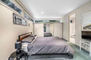 Un dormitorio con una cama grande y un televisor. en Sandcastle Haven, en Inverloch