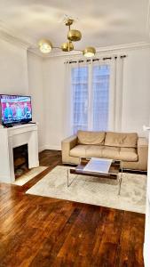 un soggiorno con un divano e un tavolo di Guest House Tour Eiffel Paris a Parigi