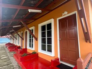 a house with a red door and red stairs at The SeaShell Chalet Melaka Kuala Sg Baru in Kampung Kuala Linggi