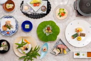 a table topped with plates of food on top at Hotel Regina Kawaguchiko in Fujikawaguchiko