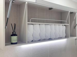 a bathroom with white towels on a shelf at Jamsil Seokchon-dong #Lotteworld #Seokchonlake #Lottetower #KSPO DOME #stadium in Seoul