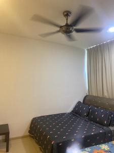 a bedroom with a couch and a ceiling fan at Vista Alam Roomstay Homestay in Shah Alam