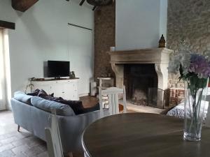 Una sala de estar con un sofá y una chimenea. en Maison de charme dans un cadre exceptionnel, en Blennes