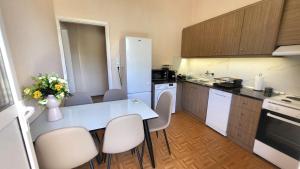 una cucina con tavolo e sedie bianchi di Mini-villa Central Park near the beach a Lagonissi