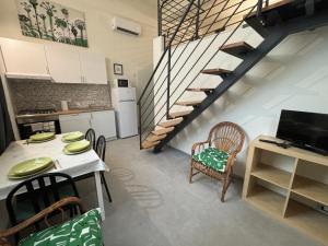 a kitchen and dining room with a table and a staircase at Loft 1-2-3, in centro, con giardino, a 150 m dal mare in Pineto