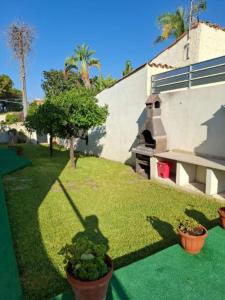 a shadow of a person on the grass next to a house at Villa near the sea in full relaxation - large garden wi-fi in Fontane Bianche