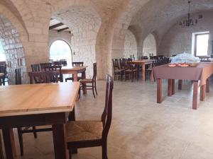 a dining room with wooden tables and chairs at Masseria Santolomuto in Noci