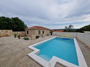 a swimming pool on a patio next to a building at House Yara Dalmatia in Kruševo